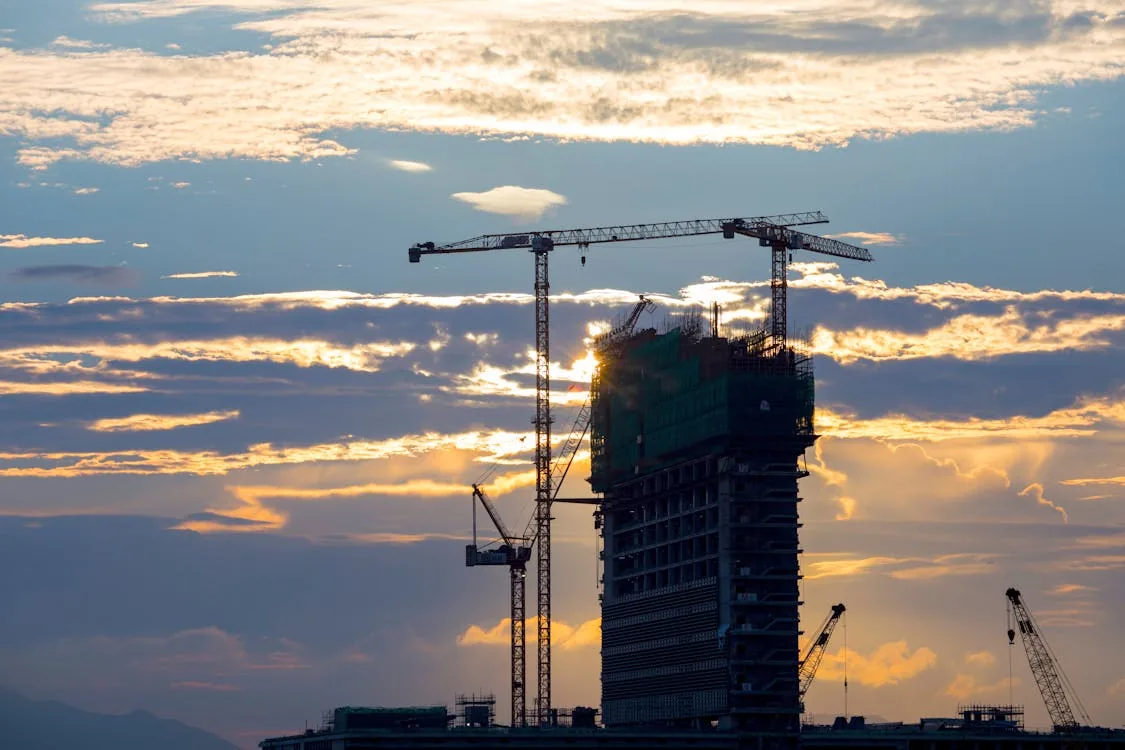 Construction cranes at sunset